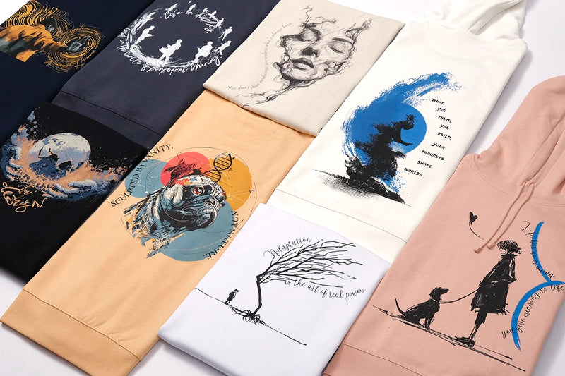A selection of TOLS graphic clothes in various colours, featuring artistic illustrations, symbolic imagery, and philosophical typography inspired by nature, identity, and human experience.