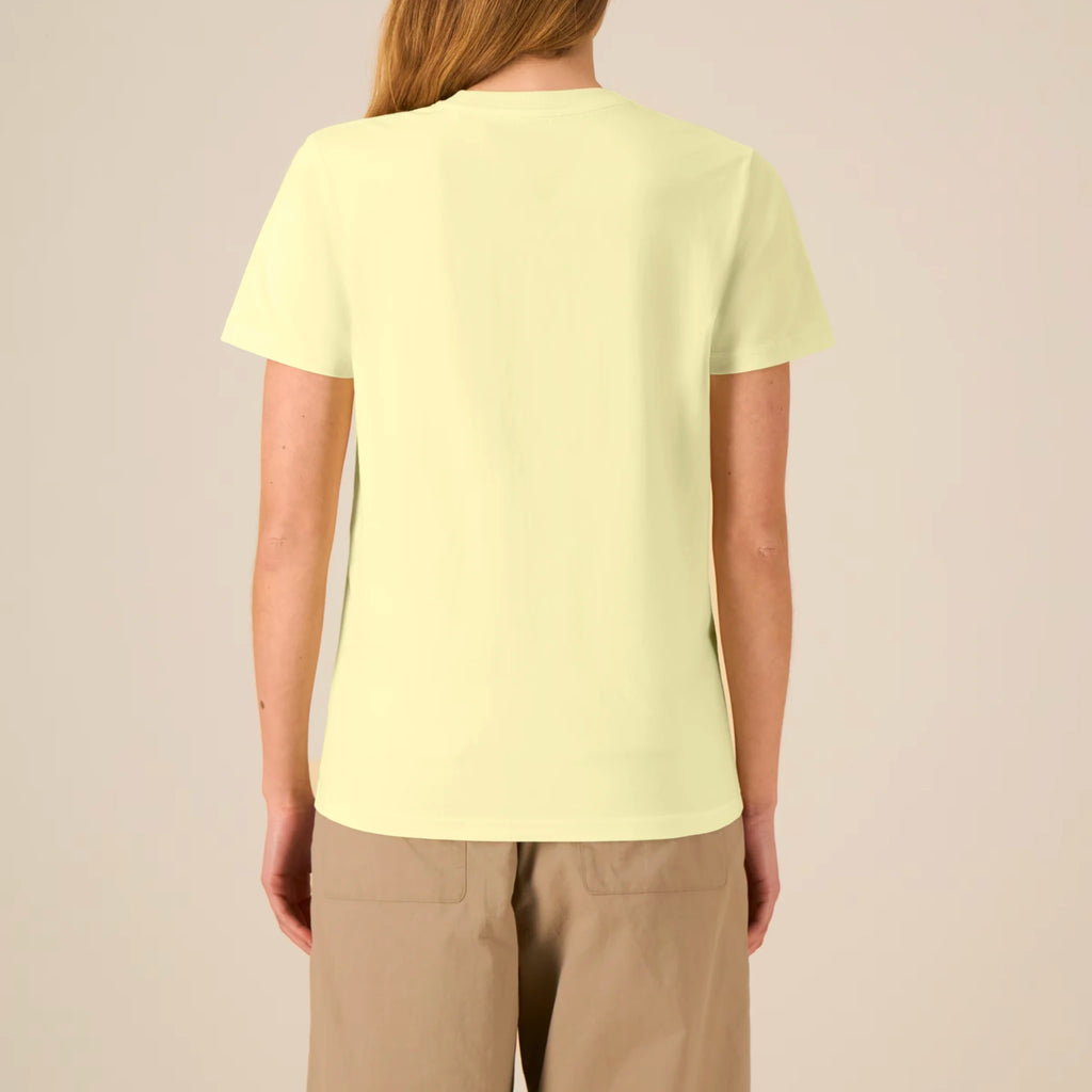 Back view of a female model wearing the TOLS Assigned Vision unisex organic cotton T-shirt in lemon sorbet color.